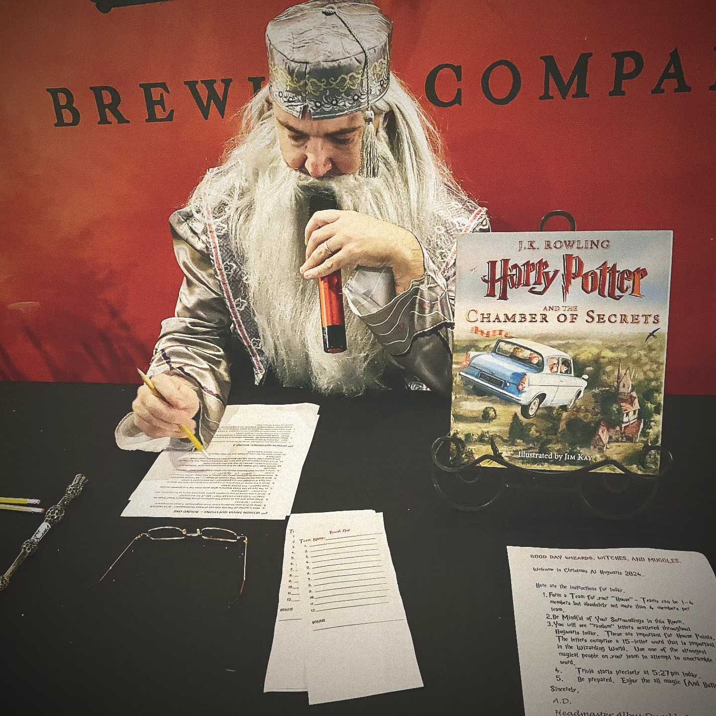 Trivia host dressed as a wizard reading questions at Christmas at Hogwarts