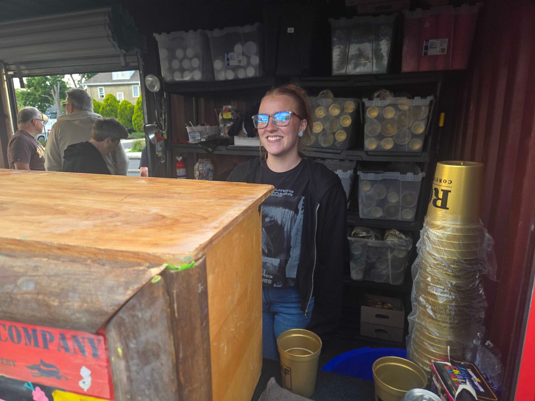 Smiling server at a Death of the Fox beer booth at an outdoor event