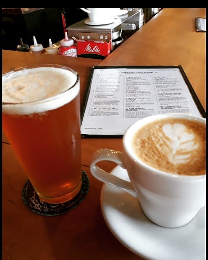 Amber beer beside a latte with latte art on the Death of the Fox bar