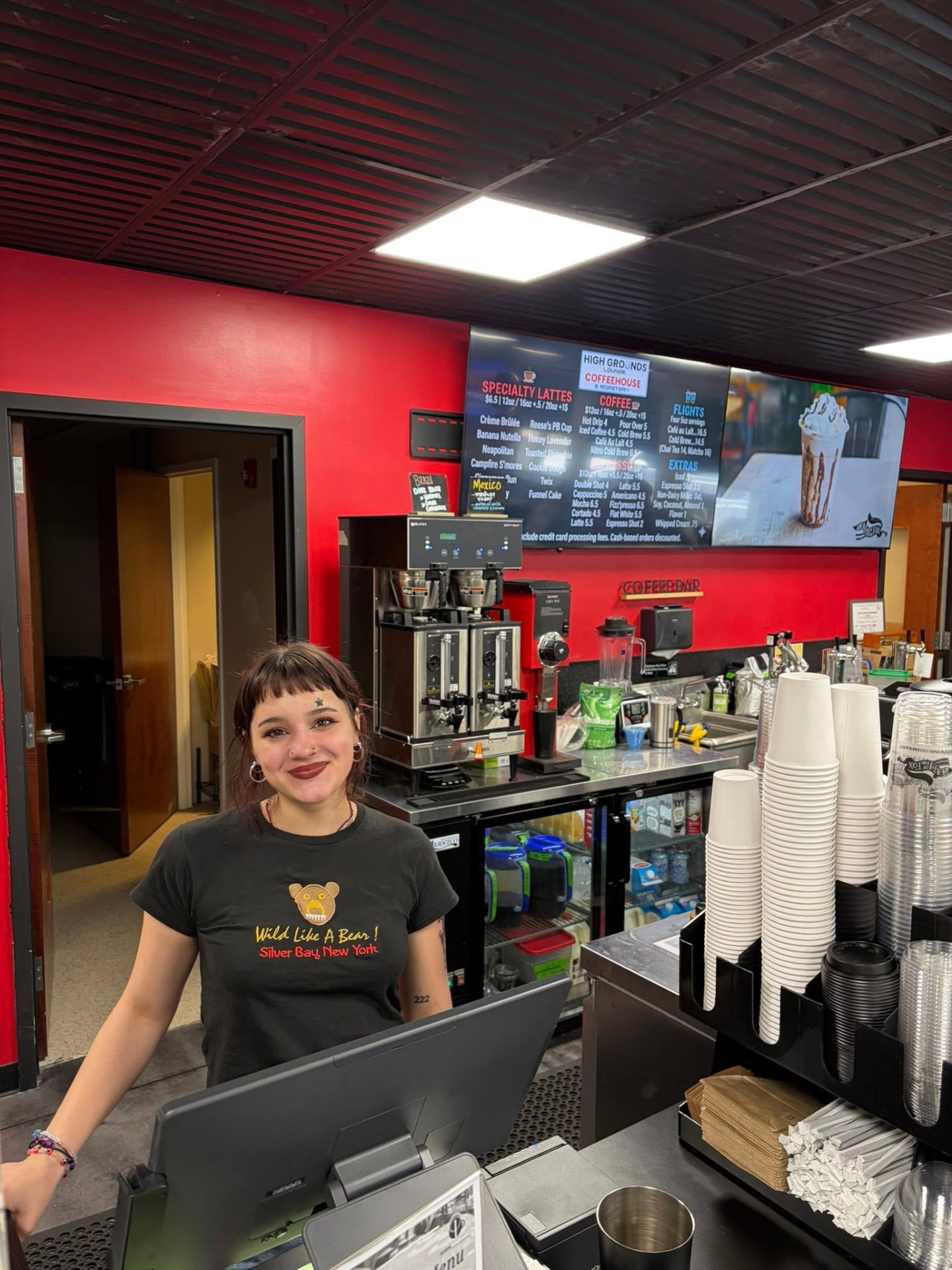 Smiling barista at the High Grounds Lounge order counter
