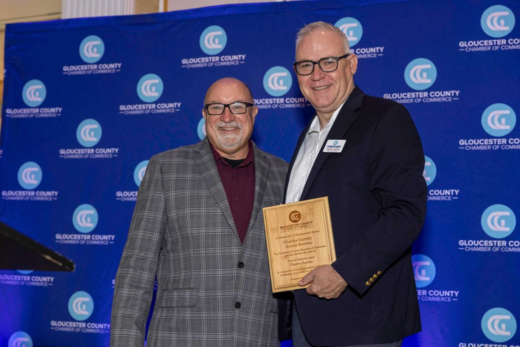 Founder holding a Director Emeritus plaque from the Gloucester County Chamber of Commerce