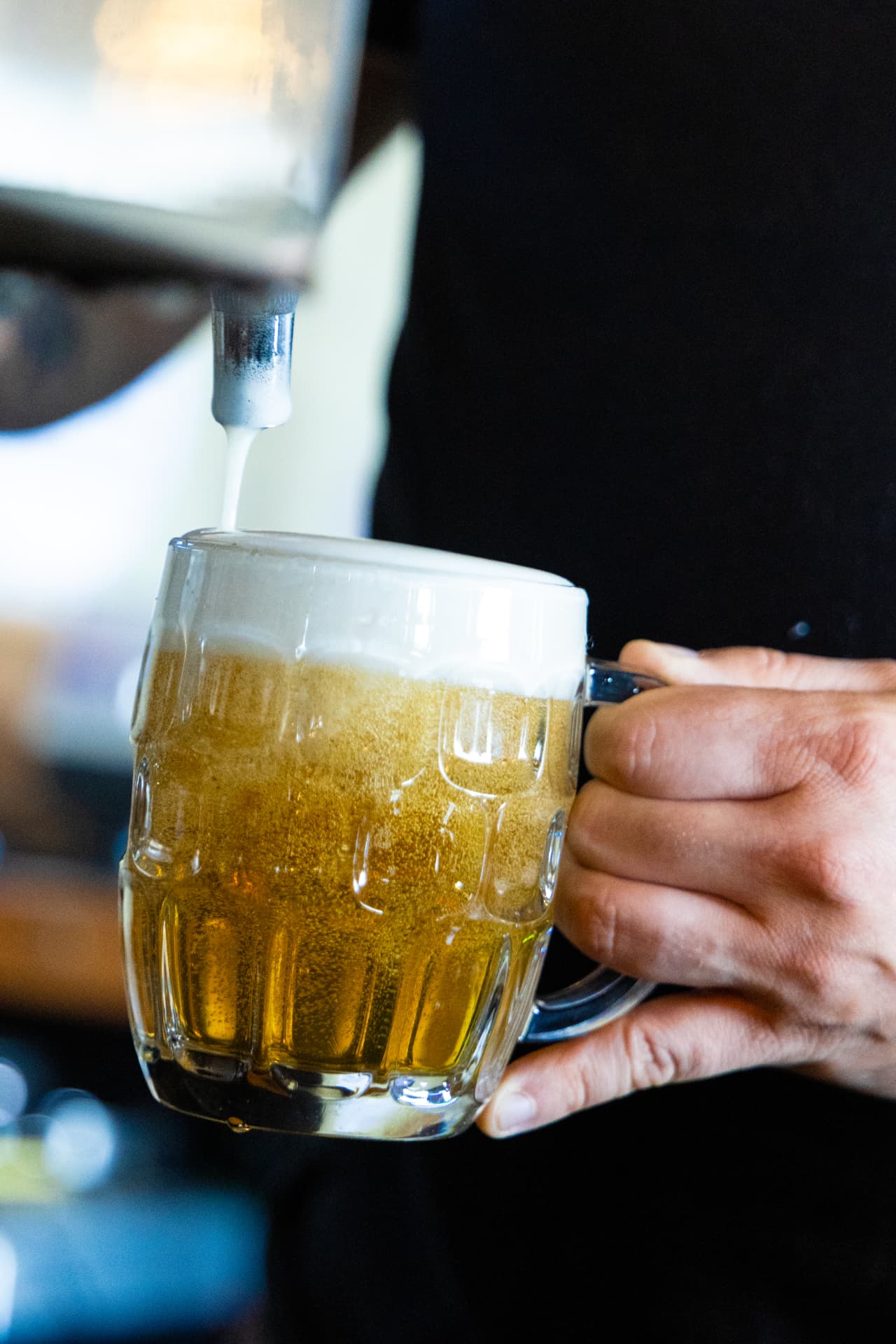 Beer pouring from the tap into a dimpled glass mug at Death of the Fox