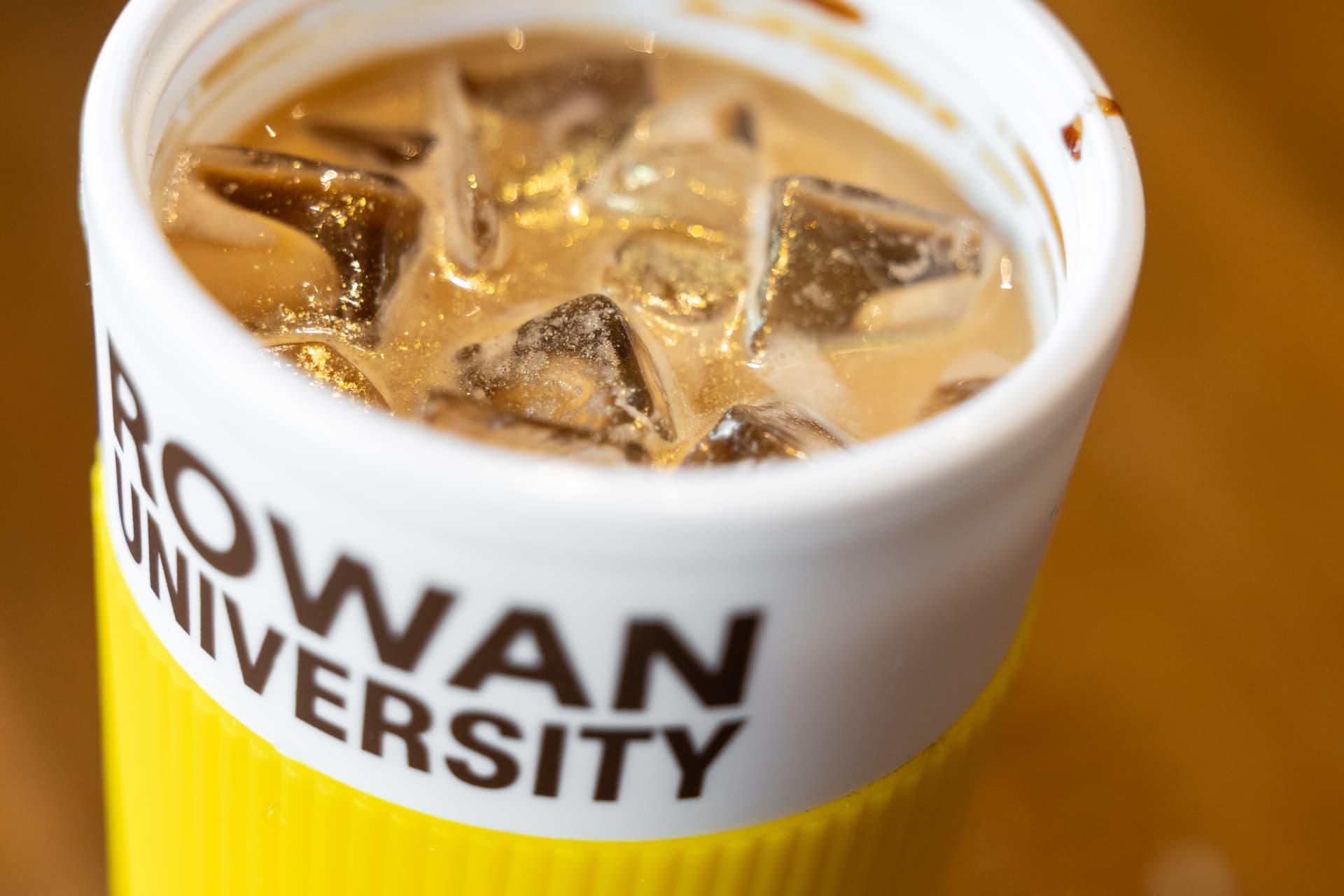 Iced coffee in a yellow and white Rowan University cup at High Grounds Glassboro
