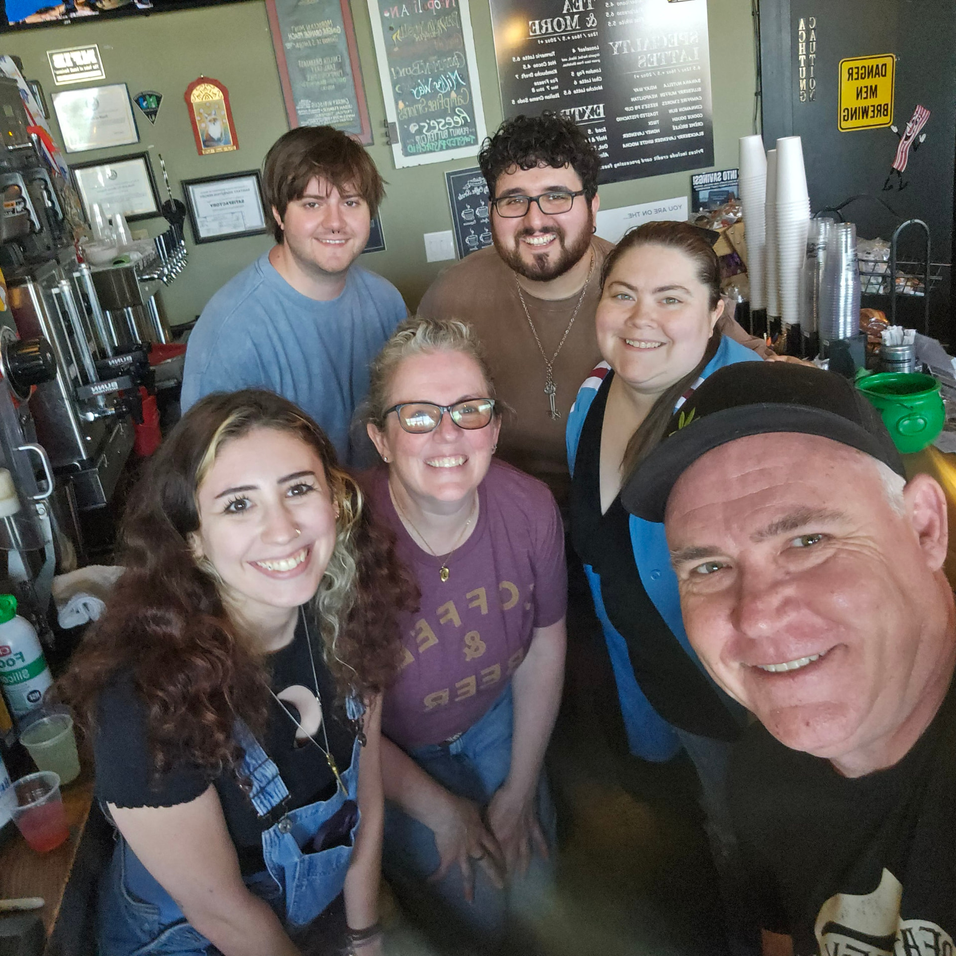 The Death of the Fox crew smiling together behind the coffee bar in Clarksboro