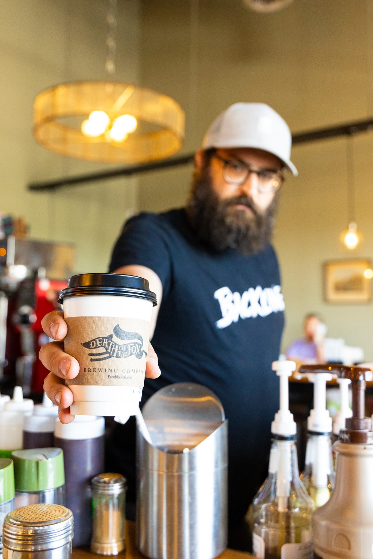 Bartender handing over a coffee to go